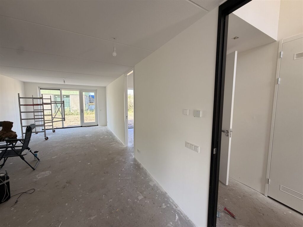 Doorkijk door een nieuwbouwwoning met egale witte wanden
