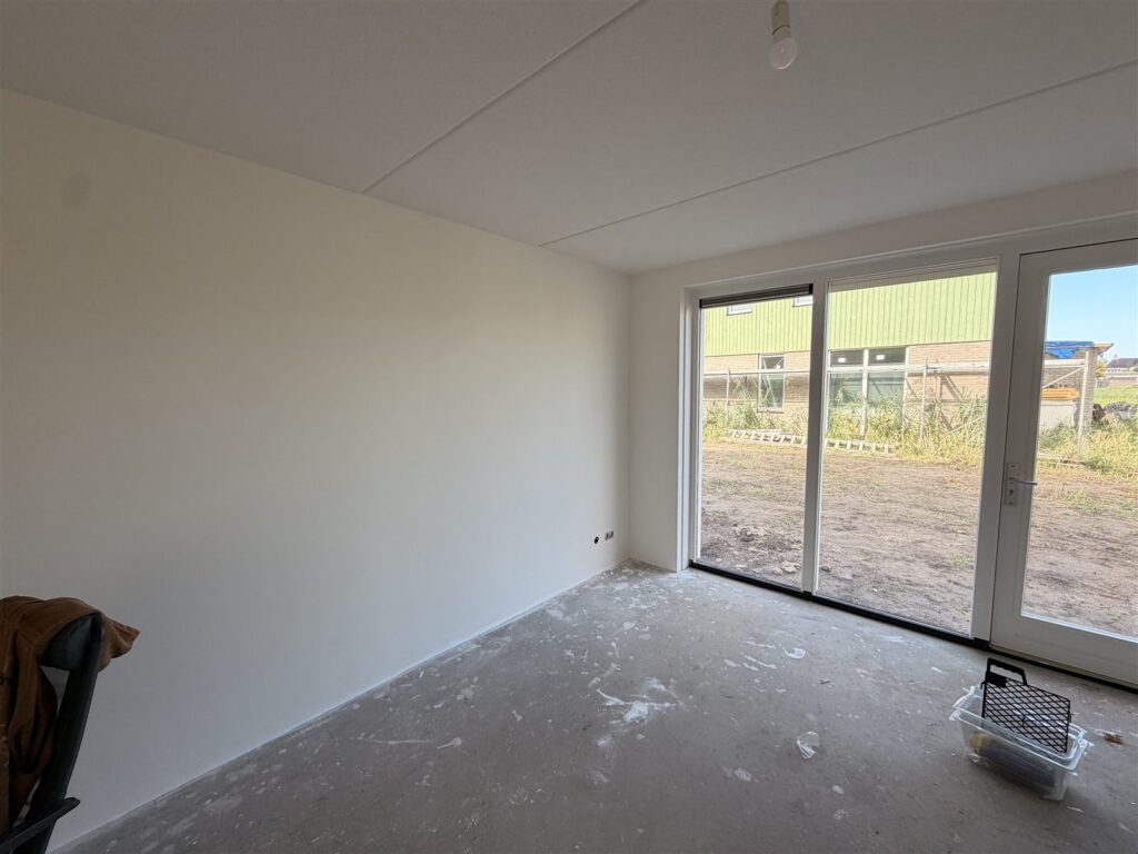 Nieuwbouwkamer met egale witte wanden na het plakken en sauzen