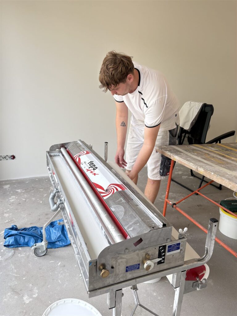 Rol glasvliesbehang in de lijmmachine, klaar om in te lijmen