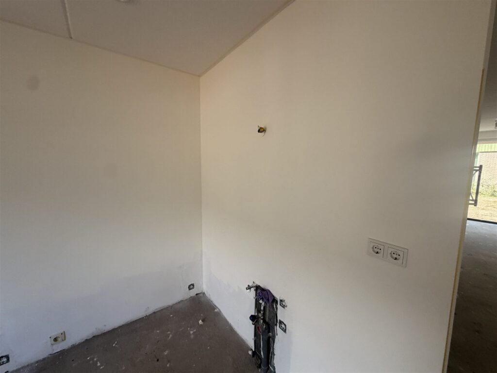 Witte wand met stopcontacten in een nieuwbouwwoning
