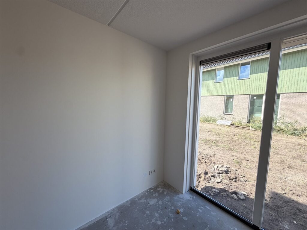 Woonkamer in een nieuwbouwwoning met strakke, wit gesausde wanden van glasvliesbehang
